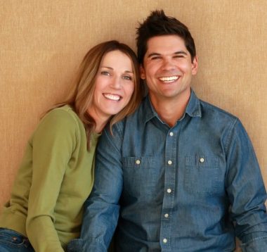 a woman and a man smiling and staring at the camera