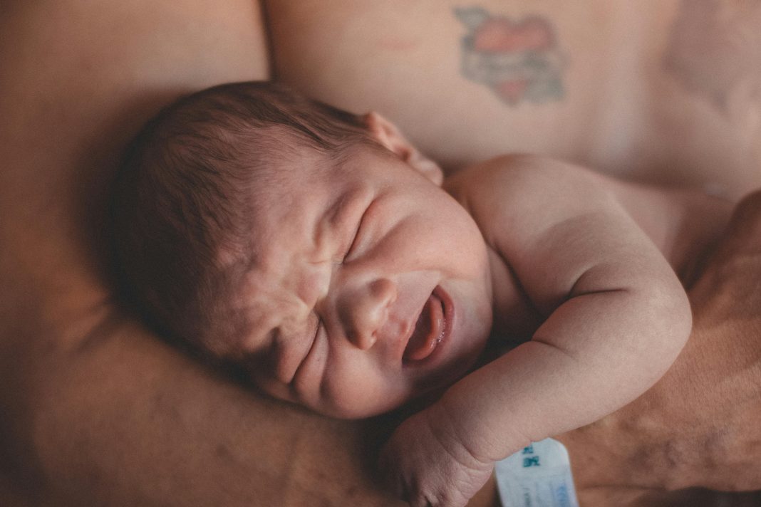 baby's stress in parents arms, presumably dad.