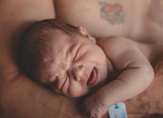 baby's stress in parents arms, presumably dad.