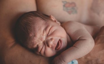 baby's stress in parents arms, presumably dad.