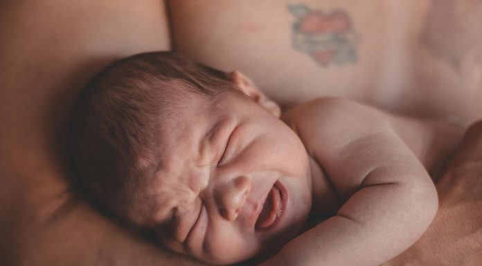 baby's stress in parents arms, presumably dad.