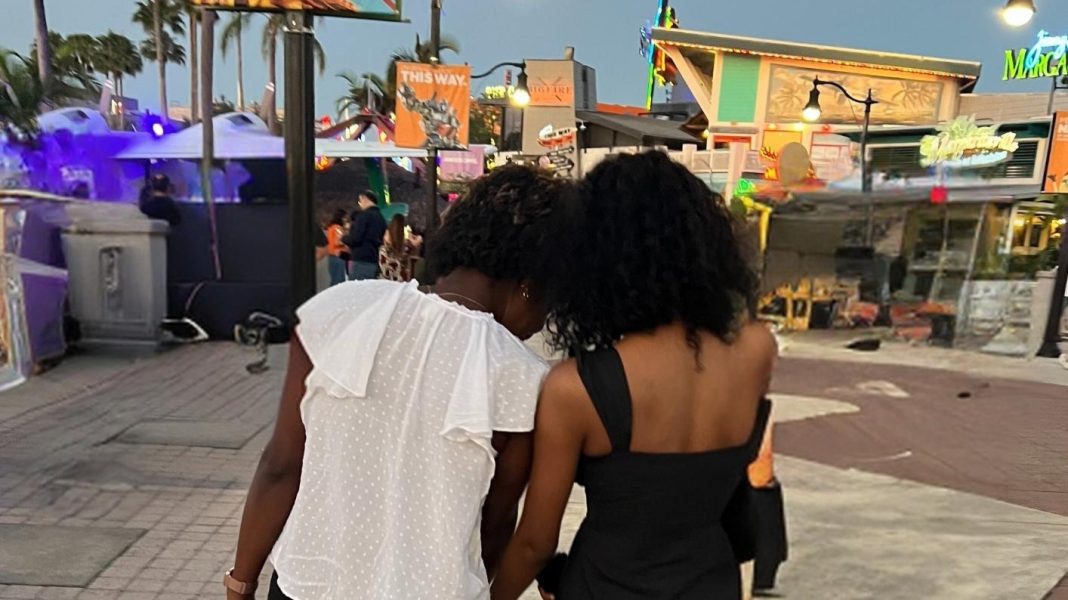 two women facing away from the camera. the younger one is leaning against the older one. Letting go as a parent