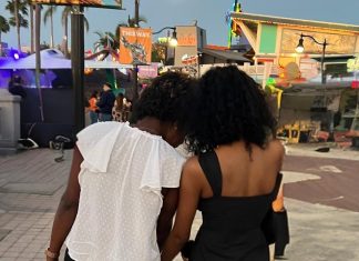 two women facing away from the camera. the younger one is leaning against the older one. Letting go as a parent