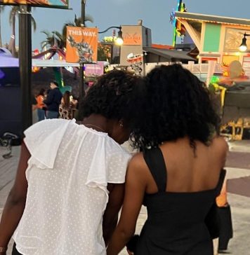 two women facing away from the camera. the younger one is leaning against the older one. Letting go as a parent