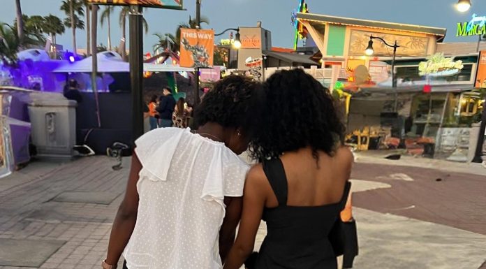 two women facing away from the camera. the younger one is leaning against the older one. Letting go as a parent