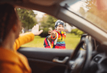 mom waving goodbye to child, a boy, boy smiling and waving back; back to school mom mental health