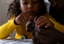 introducing kids to sewing: a young girl sewing a stuffed animal with parent