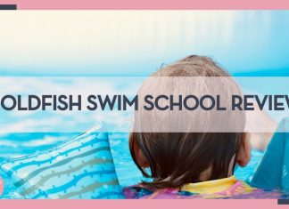 the back of a child's head in a pool with blue and green striped floats on their arms with words 'goldfish swim school review' overtop