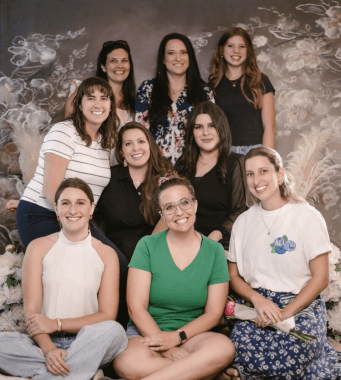 9 women smiling at the camera. mom tribe