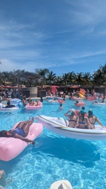 many women sitting on floaties enjoying their momcation on a adult-only cruise, stop in Bimini