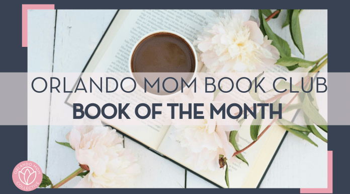 black coffee in white mug on open book with flowers and leaves on stems on the book and white table below book