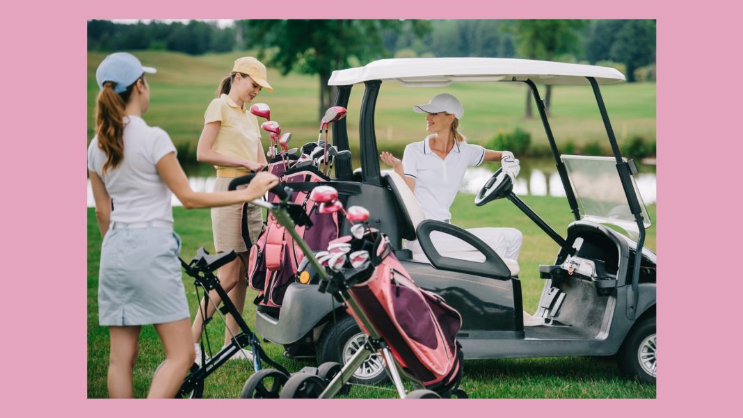 three women talking t each other while a golf retreat with golf clubs and golf cart