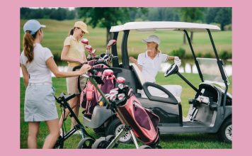 three women talking t each other while a golf retreat with golf clubs and golf cart