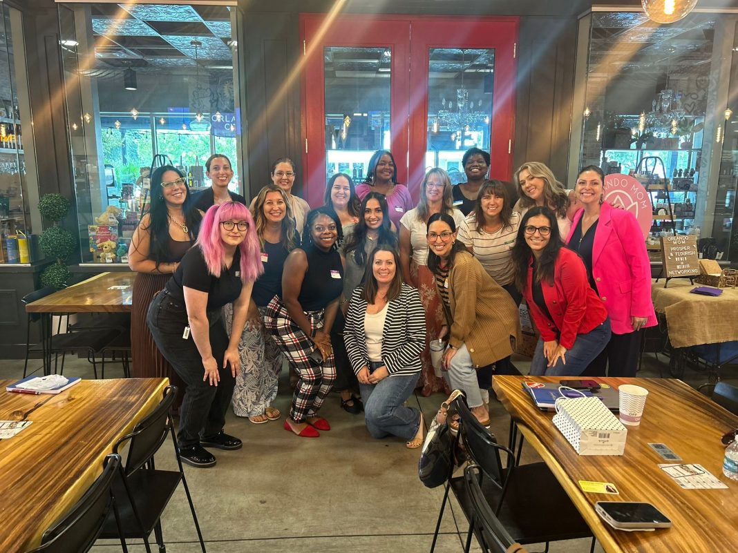 17 women smiling at the camera for prosper and flourish in which some are mom entrepreneurs, child-free woman, or just women in business