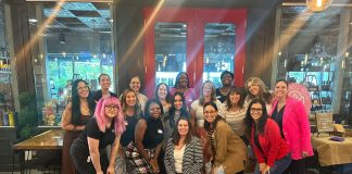 17 women smiling at the camera for prosper and flourish in which some are mom entrepreneurs, child-free woman, or just women in business