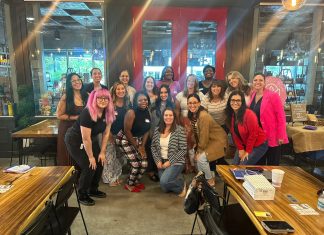 17 women smiling at the camera for prosper and flourish in which some are mom entrepreneurs, child-free woman, or just women in business