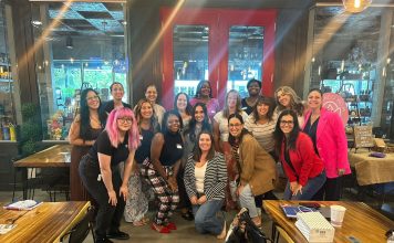 17 women smiling at the camera for prosper and flourish in which some are mom entrepreneurs, child-free woman, or just women in business