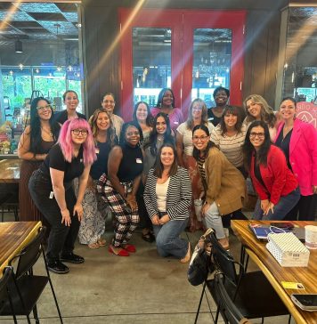 17 women smiling at the camera for prosper and flourish in which some are mom entrepreneurs, child-free woman, or just women in business