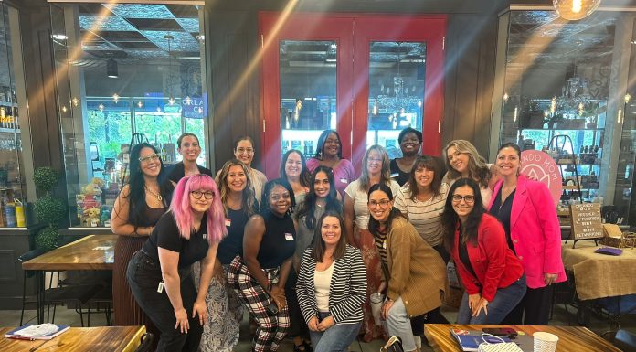 17 women smiling at the camera for prosper and flourish in which some are mom entrepreneurs, child-free woman, or just women in business