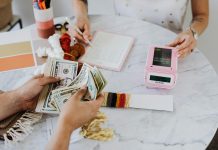 two people at a table with calculator and money, budgeting to financial freedom