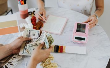 two people at a table with calculator and money, budgeting to financial freedom