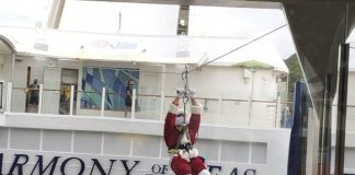Cruising over the Holidays: Is it worth it? santa ziplining across the atrium of a cruise ship; cruising over the holidays