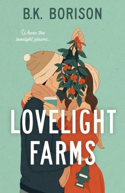 a couple dressed for winter kissing with mistletoe hanging over their faces  with words 'love light farms' overtop of them