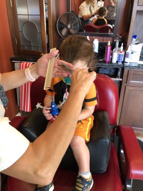 young boy cutting his first haircut at disney world