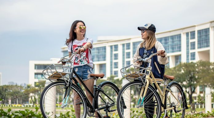 two men laughing on bicycles with a city scape in the back. Waiting for the latest travel trend