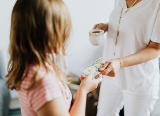 young girl receiving money from probably mom (out of frame) to invest in your child's future