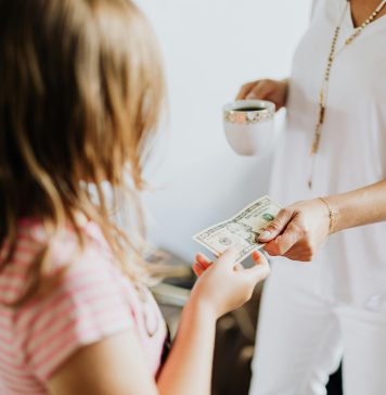 young girl receiving money from probably mom (out of frame) to invest in your child's future