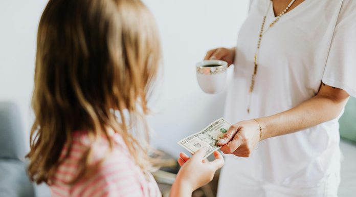 young girl receiving money from probably mom (out of frame) to invest in your child's future