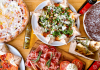 flat lay of food, mostly pizza and italian food, on an inviting table for restaurant for families with kids