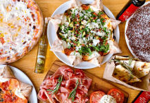 flat lay of food, mostly pizza and italian food, on an inviting table for restaurant for families with kids