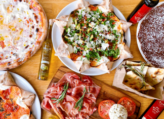 flat lay of food, mostly pizza and italian food, on an inviting table for restaurant for families with kids