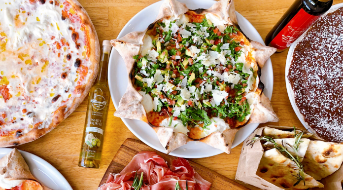 The Perfect Restaurant for Families with Kids flat lay of food, mostly pizza and italian food, on an inviting table for restaurant for families with kids