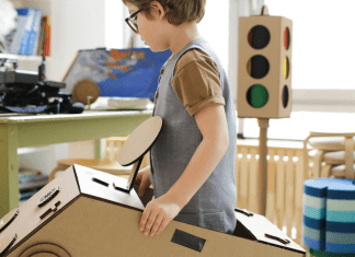 little boy with glasses in a cardboard box that looks like a car, playing pretend, child car accident trauma recovery