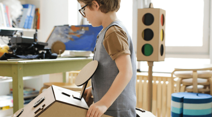 Child Car Accident Trauma Recovery: little boy with glasses in a cardboard box that looks like a car, playing pretend, child car accident trauma recovery