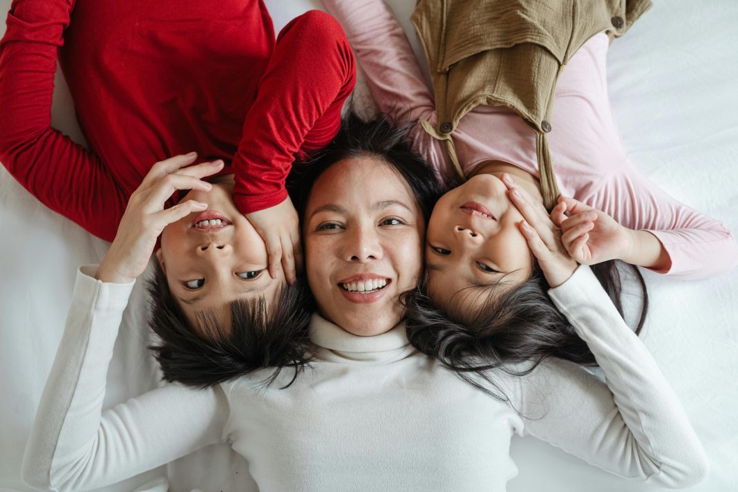 a mom with her two children; all three smiling up at the camera; myths of motherhood