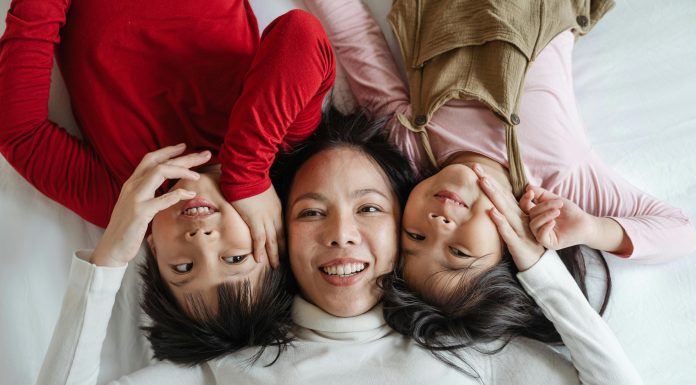 a mom with her two children; all three smiling up at the camera; myths of motherhood