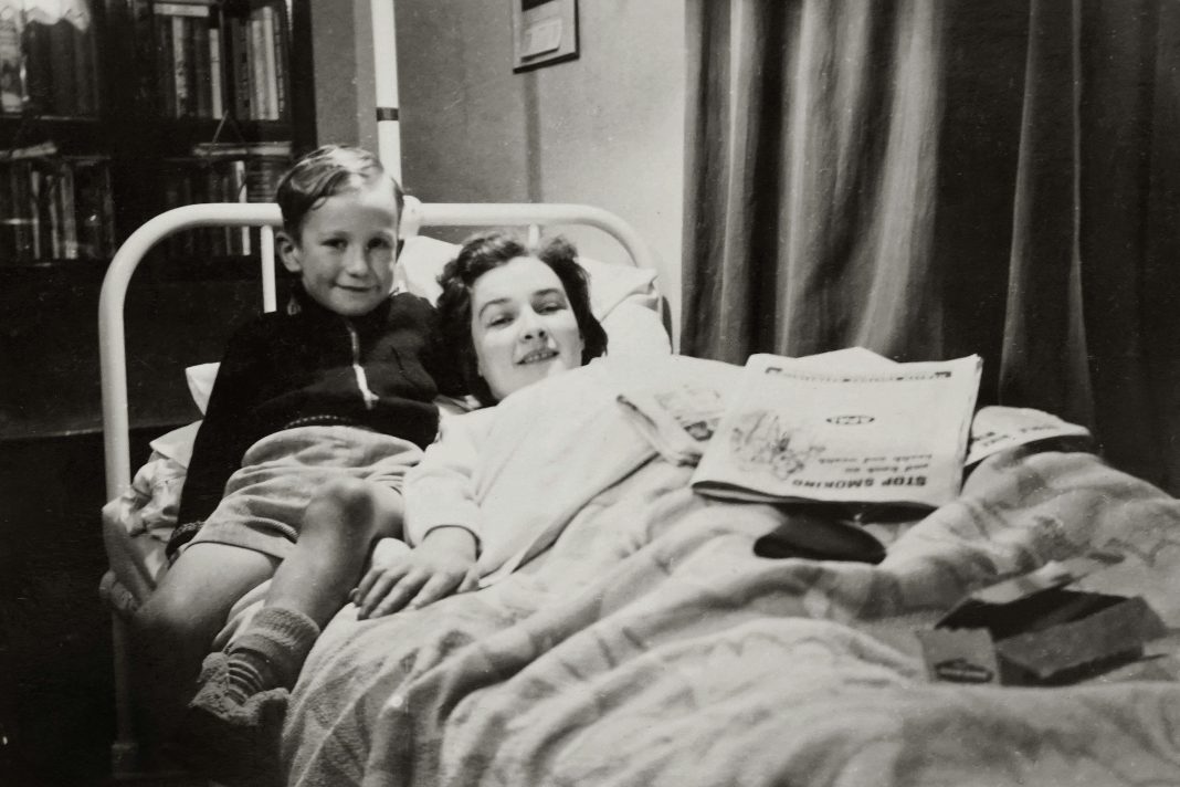 woman, mom, lying in bed with her son next to her. older photo, Balancing Motherhood and Recovery