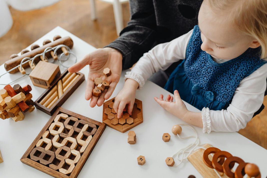 pexels-karolina-grabowska-7296819 young child playing on mother's lap with games for autism acceptance month in april