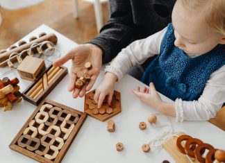 young child playing on mother's lap with games for autism acceptance month in april