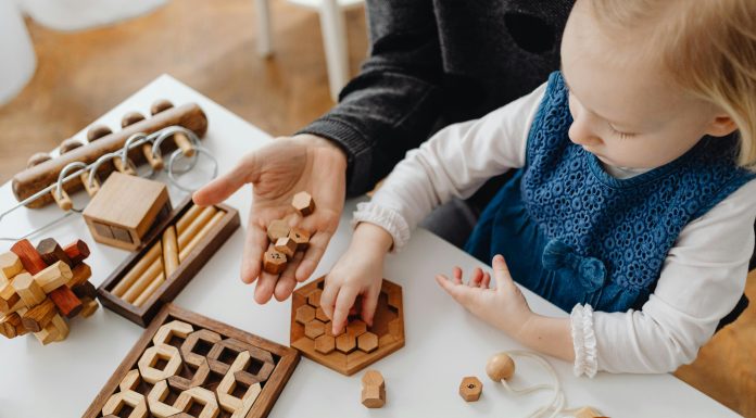 young child playing on mother's lap with games for autism acceptance month in april