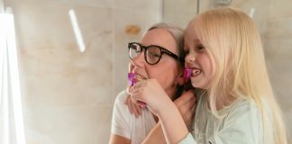 Mom and daughter brushing each other's teeth in the mirror; Hydroxyapatite