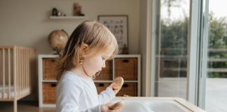 child in sensory play with smooth rocks and dry macaroni