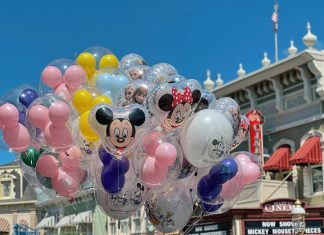 What to Pack for a Family Trip to Orlando (By a Mom Who Lives Here) Colorful Disney balloons float in front of a Main Street, U.S.A. building at Magic Kingdom in Orlando, featuring Mickey, Minnie, and Frozen characters—perfect snapshot of what to expect (and what to pack for a family trip to Orlando).