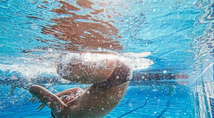 Water Safety and a Beach Day: Smart Tips for a Fun, Safe Summer Swimmer performing an underwater flip turn in a pool, highlighting athletic skill and promoting water safety awareness.