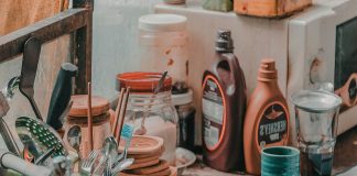 Kitchen counter crowded with utensils, jars, and sauce bottles illustrating the mental load of clutter during busy summer days