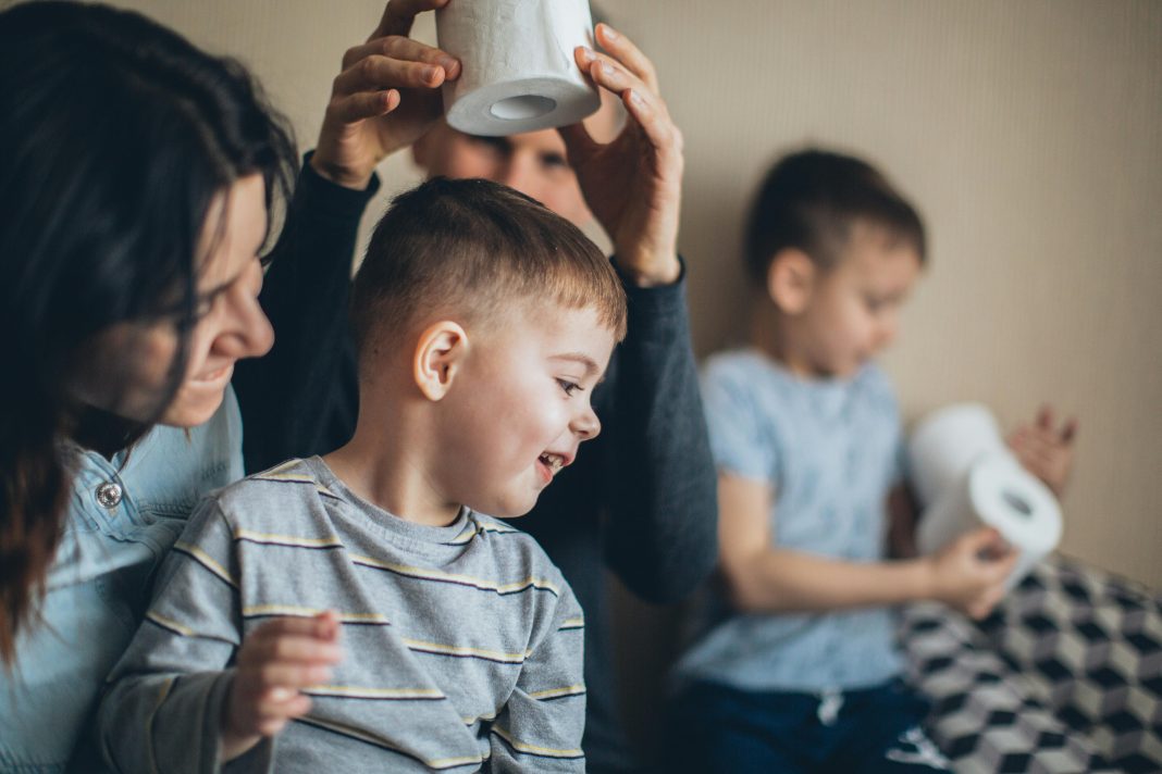 pexels-elly-fairytale-4008772 Mother and children sitting together at a table, smiling and talking, highlighting family routines and public health awareness.